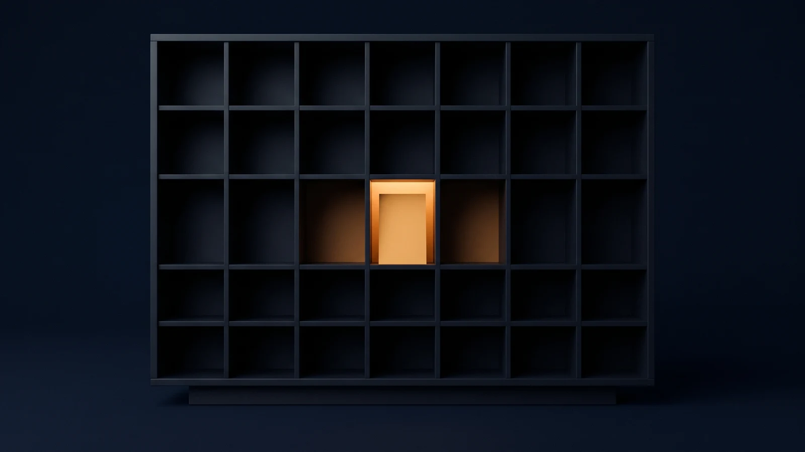 A broad open sorting frame of matte near-black charcoal standing dead-on on a low base in a deep blue void, its face divided into a wide grid of identical square compartments left empty and dark, one single compartment near the center holding a completely blank upright card with its interior washed warm amber from behind