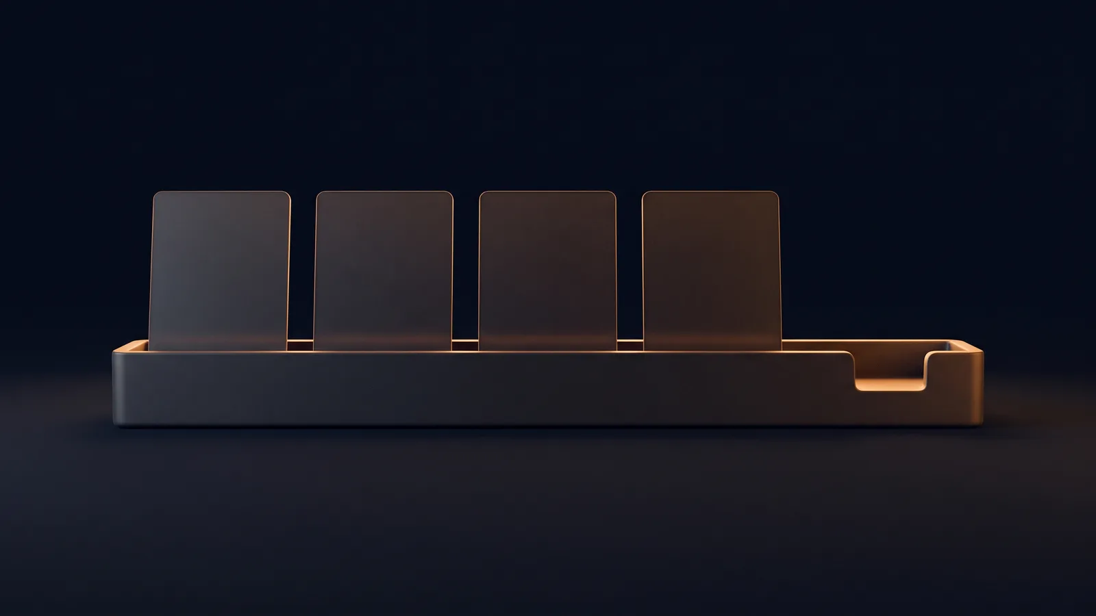 A long low blank dark card holder lying across a surface in a deep blue void, four identical unmarked cards standing upright in its channel and read by thin warm rims, and the fifth position at the right end holding no card, its empty notch lit warm amber