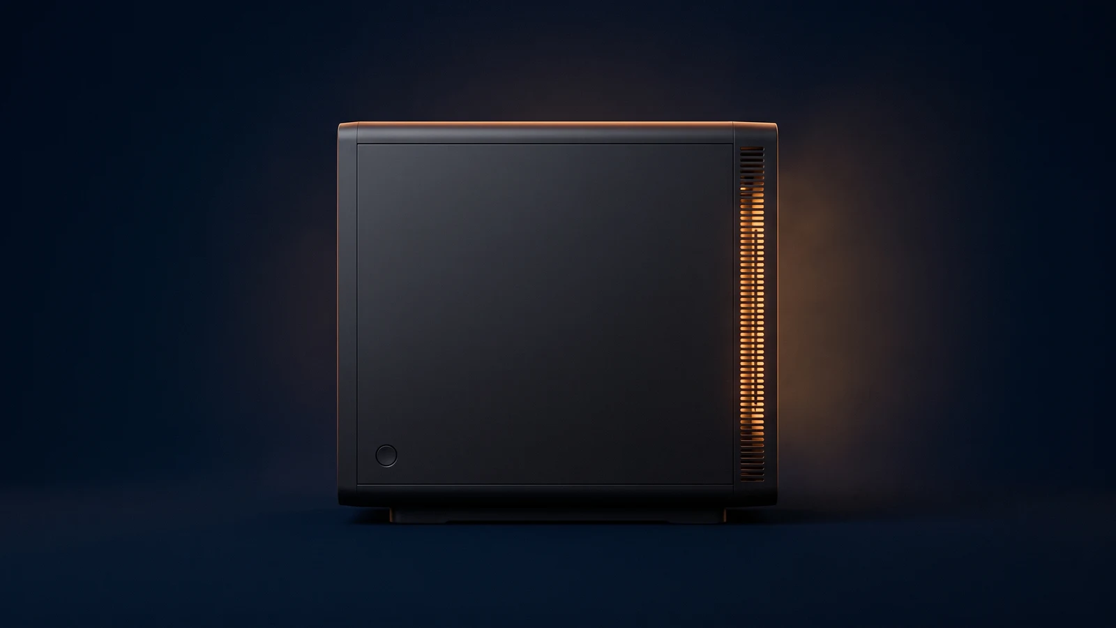 A broad small-form-factor desktop computer of matte near-black charcoal standing dead-on in a deep blue void, its front face completely blank apart from one dark round button, a tall column of fine vent slots down its right side lit warm amber from deep inside the housing