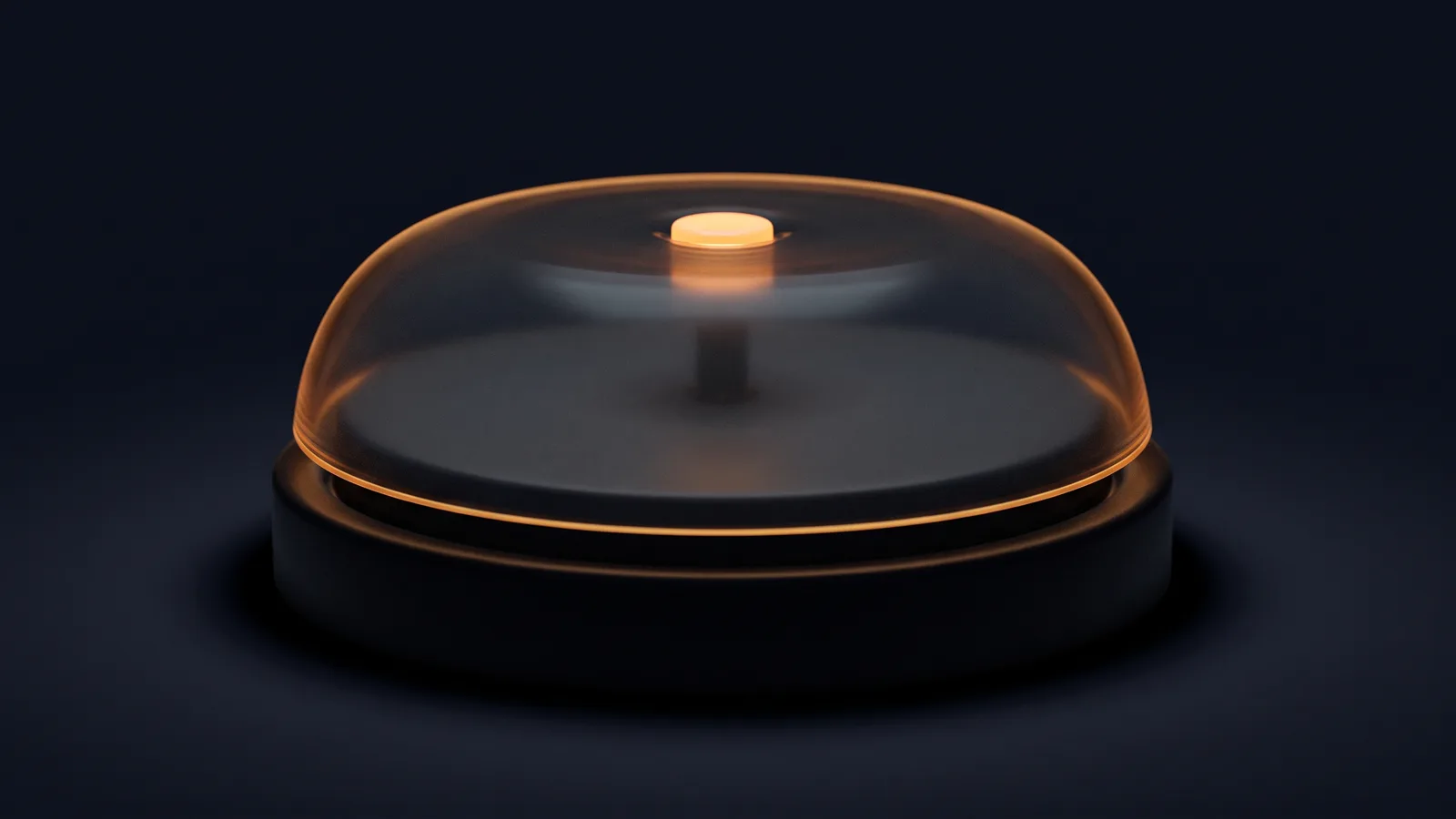 A broad reception desk bell in a deep blue void, its low dome made of dark smoked glass with a thin amber rim on a round near-black base, and the small push button on top glowing warm amber