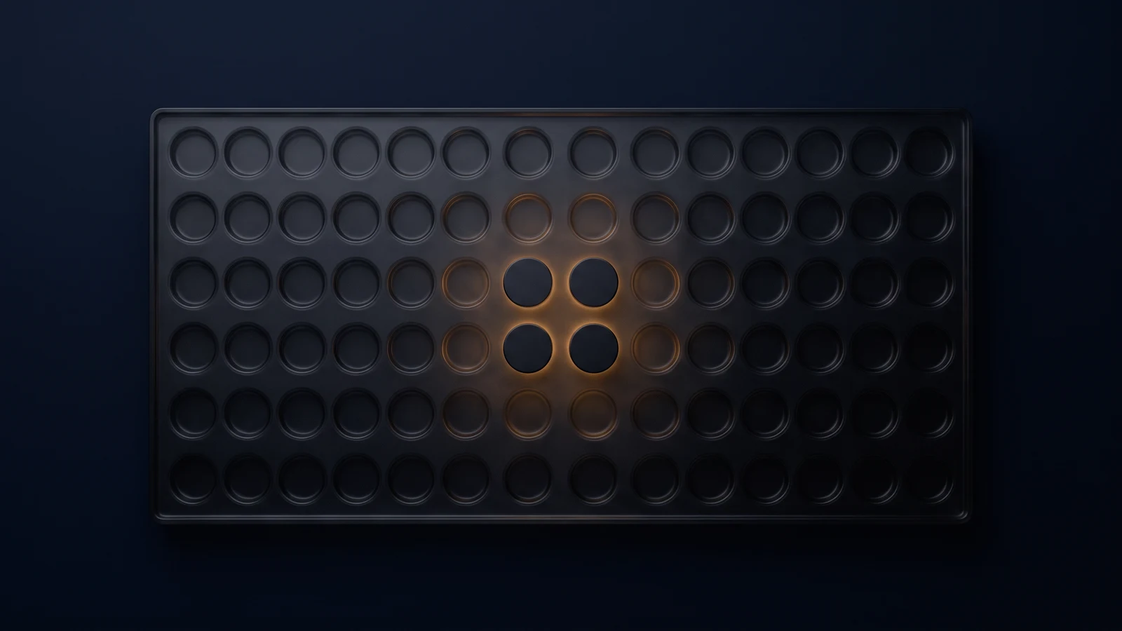 A broad flat tray of dark smoked glass seen from directly above in a deep blue void, its face an even grid of shallow round wells all empty and dark, with four wells in one cluster near the center each holding a blank disc washed dimly warm amber